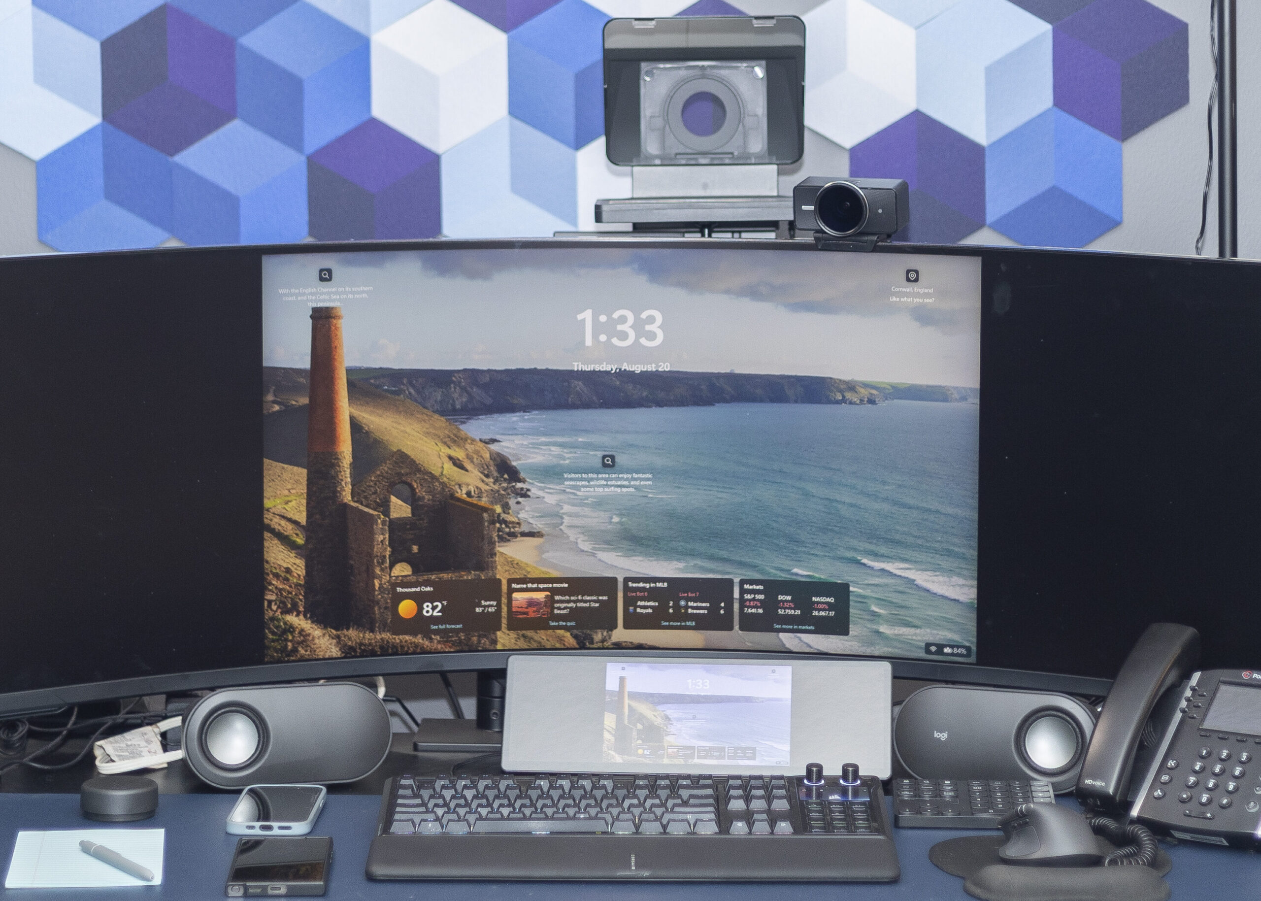 A home sales desk: curved ultrawide monitor, keyboard, mouse and speakers.