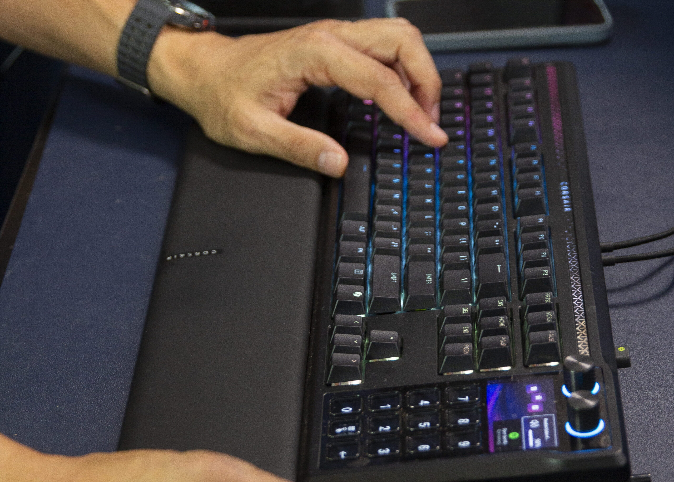 Hands on a backlit mechanical keyboard and mouse at a home sales desk.