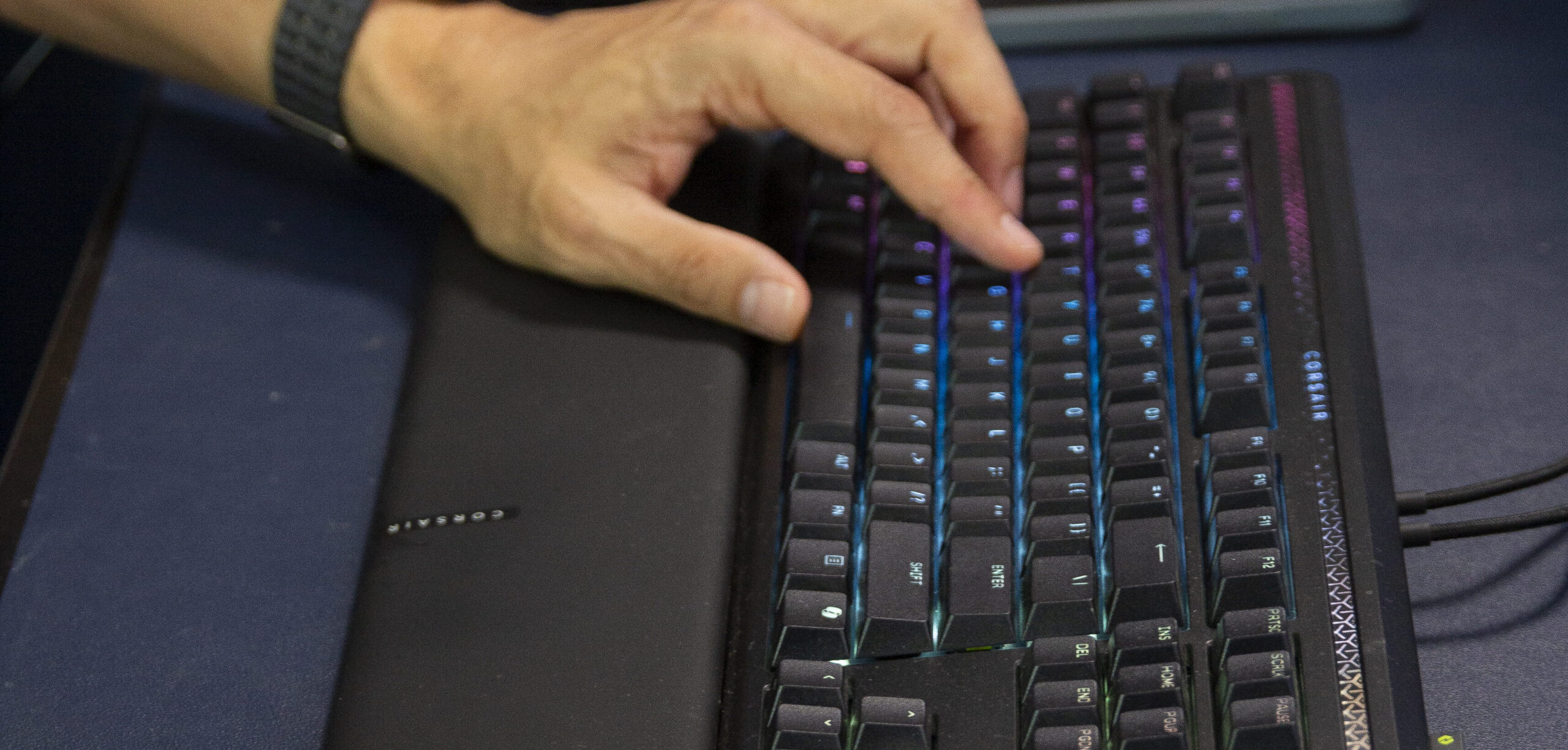 Hands on a backlit mechanical keyboard and mouse at a home sales desk.