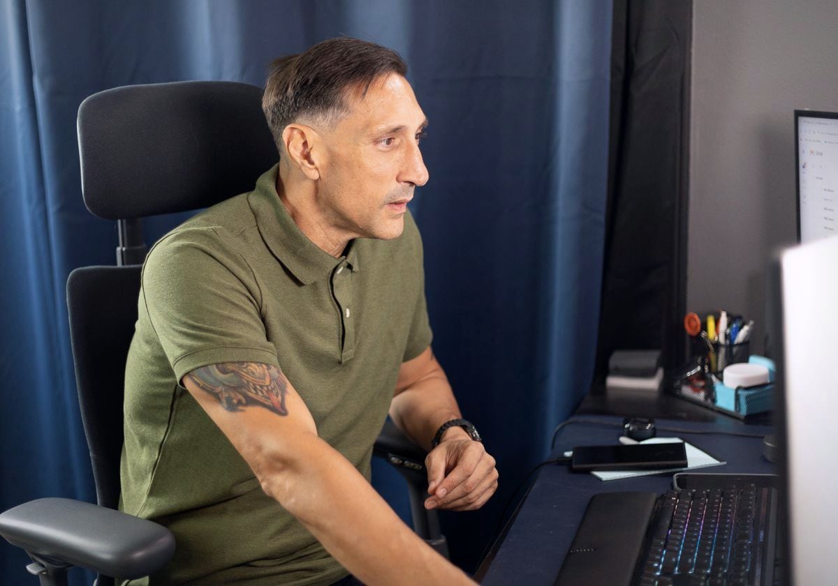 Jarrod Roberts at his desk, looking at his screen mid-workday.