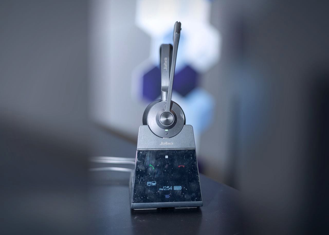 A wireless headset standing on its charging base.