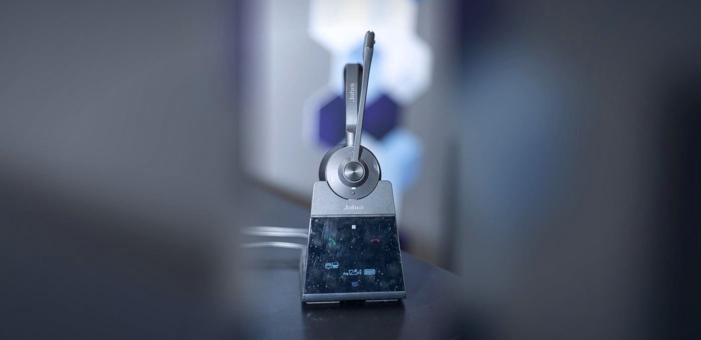 A wireless headset standing on its charging base.